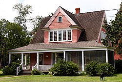 Pink house with large gables and a porch.