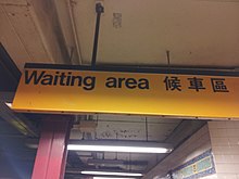 A sign hanging from the ceiling, with the words "Waiting Area" in English and Chinese
