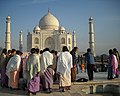 Tourists from North-East India, wrapped in sarongs and shawls, visit the Taj Mahal.