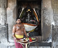 A pujari outside a Ganesha shrine