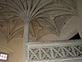 Stone staircase with central column and palm tree vaulting.