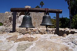 Two of the original bells (San Vicente and San Juan) sit on display within the footprint of the original bell tower at Mission San Juan Capistrano. Damage to the smaller bell (San Juan), sustained during the 1812 earthquake, is readily apparent in this view.