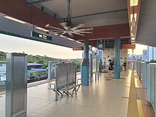 View of the island platform with half-height platform barriers separating passengers from the tracks