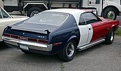 Shows the rear quarter of a 1970 Javelin Trans-Am with the factory paint scheme and rear spoiler