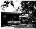 The front porch of a house, surrounded by lush greenery