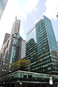 Lever House as seen in 2014. The main tower is to the right, while the building's three-story base occupies the foreground. Several other buildings are visible at left.