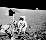 Astronaut Pete Conrad studies the Surveyor 3 probe on the surface of the Moon