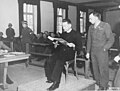 Polish priest Theodore Korcz (left) reads from the Malaria protocols on 22 November 1945