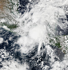 Satellite image of a large, somewhat disorganized mass of clouds near a landmass