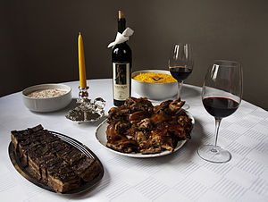 Typical Christmas table in Serbia. Grilled pork, Olivier salad (also called Russian salade), dzadziki salade, red wine and Bajadera sweets.