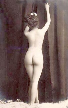 Photograph of the back of a woman with an hourglass figure (c. 1900)