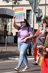 A woman holding a "Born This Way" sign.