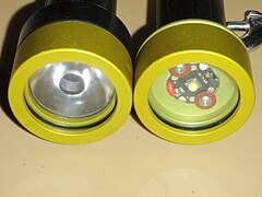 Comparison between two dive lights with the same LED; with lens on left and without lens on right