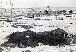 Restored version: four bodies visible in foreground partially wrapped in blankets.