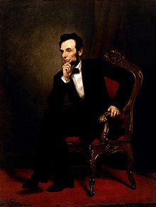 A painting depicting President Lincoln seated in an ornate wooden armchair. He wears a black suit and bow tie. He is leaning forward, legs crossed, with one hand on his chin.