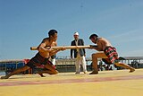 I-22 (North-Eastern Traditional) Insuknawr, a traditional sport of Mizoram state in North-East India. Two combatants each gripping one end of a pole (normally used as a pestle for pounding rice) try to push the other out of a designated zone.