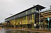 Picture of Kellyville station from the outside. It consists of an elevated platform with a glass façade.