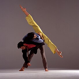 现代舞舞者在表演劈叉，靠另一名舞者来平衡