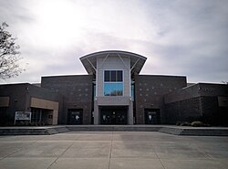 Photo of the main entrance of the school, featuring four gates and the large second story windows of the library.