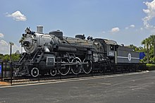 An old steam locomotive on static display with faded paint