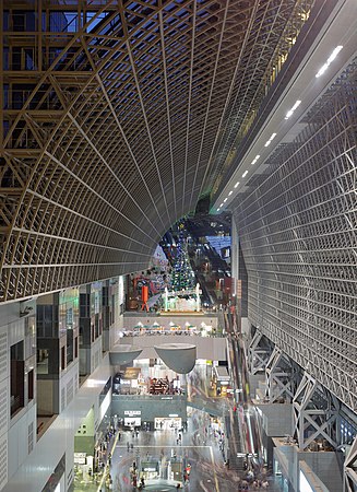 图为日本京都车站，为京都最主要的火车站和交通枢纽。该车站为日本第二大车站，总共有15个楼层，车站内还有购物商场、旅馆、电影院、伊势丹百货公司，和数个当地政府机构。目前的车站结构在1997年完工开放，以纪念平安建都1200年。京都车站高70米，东西两端总长430米，总楼层面积238,000平方米。建筑师为原广司，车站钢架上的安装了不规则突出的平面玻璃，具有未来主义风格。