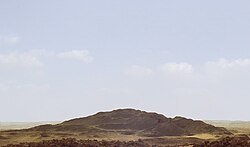 Ruined heap of brownish stones in a sand desert