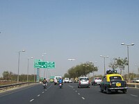 The Government of India predicts that over the next five years $1 trillion will be spent on infrastructure, half of it by India's private sector. Infrastructure investment in Delhi during the last decade has underwritten the city's metro rapid transit system, the low-floor Compressed Natural Gas (CNG) buses (red, green and orange), and wider roads. Shown here is Gurgaon Expressway.