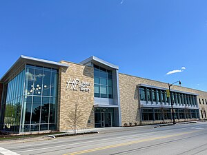 Exterior of the new library building facade, a modern glass and cream-colored brick building with the library's logo in white.