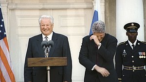 Photograph of Boris Yeltsin at White House lectern with Bill Clinton to his left, both laughing, in October 1995