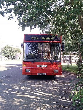 A red bus pulled over at a bus stop