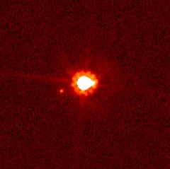 鬩神星（中央）及鬩衛一（中央偏左），以哈勃太空望遠鏡拍攝