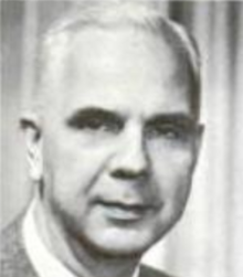 A white man with white hair, wearing a suit