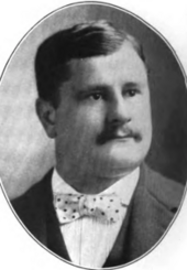 front portrait of young man with mustache, well dressed with polka-dotted bow tie