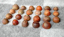 Colour photograph of 23 amber gaming pieces found in a boat grave in Skamby, Sweden