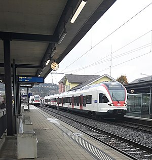 White-and-red trains on double track with side platforms