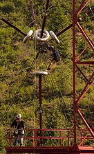 Contractors working on feed bus tower. The long insulator strings and corona rings are needed to withstand the very high voltage on the antenna