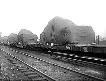 A string of flatcars carries tanks (under tarps) in April 1943