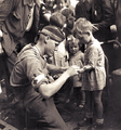 Canadian Private MacDonald gives first aid to a child