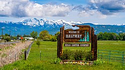 Welcome sign, in the background are the Wallowa Mountains