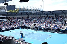 Show Court Arena during the 2023 Australian Open, with the Melbourne Cricket Ground visible in the background.