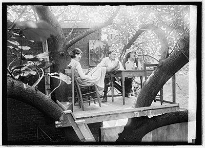 A 23-year-old Cleon "Throck" Throckmorton, 18-year-old Kathryn "Kat" Mullin,[a] and a friend wearing a tricorne hat relax in the club's tree house cafe on July 15, 1921. No photograph of the club's indoor area—the speakeasy itself—is known to exist.