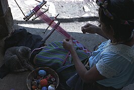 A Jakaltek Maya brocades a hair sash on a back strap loom.