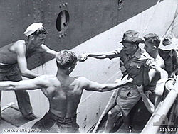 An ex-POW, newly liberated from Batu Lintang camp, being helped aboard the AHS Wanganella, 1945.