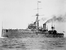 Ship at sea with smoke emitting from two funnels