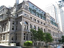 Large, 19th-century building landscaped with small trees