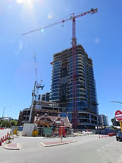 A high rise building under construction with two tower cranes