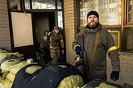 Two civilians and a soldier in a building