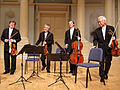 Image 28A modern string quartet. In the 2000s, string quartets from the Classical era are the core of the chamber music literature. From left to right: violin 1, violin 2, cello, viola (from Classical period (music))