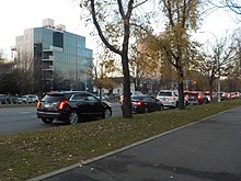 The parkway as seen near Avenue N. In the foreground is a walking path with trees, while in the background are cars sitting in traffic.