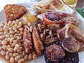 Image 69The full breakfast is among the best known British dishes, consisting of fried egg, sausage, bacon, mushrooms, baked beans, toast, fried tomatoes, and sometimes white or black pudding. (from Culture of the United Kingdom)